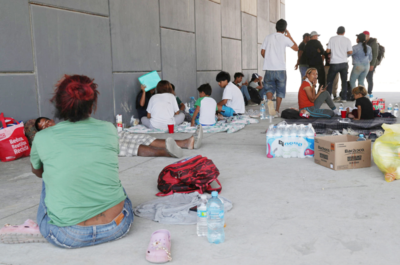 Migrantes dejan río fronterizo México-EEUU y se refugian de calor e inseguridad bajo un puente