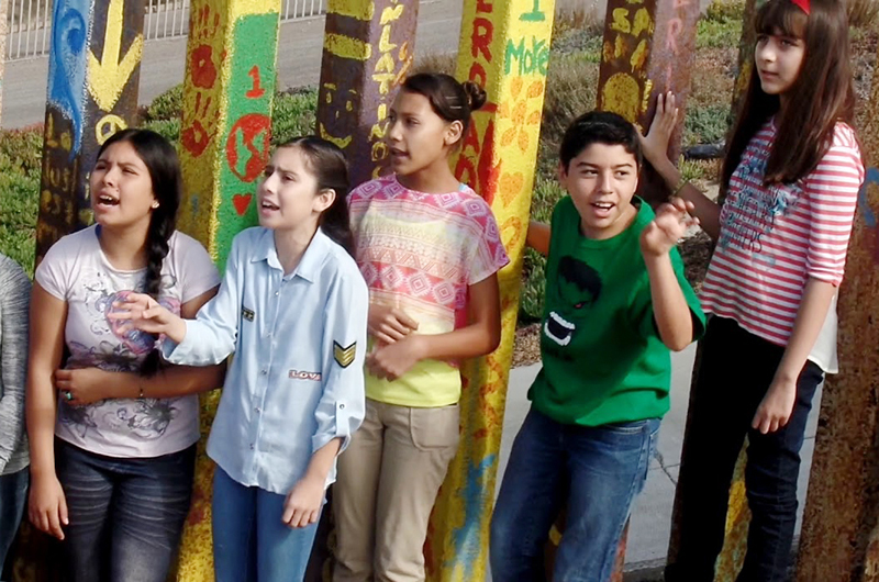 Cantaron niños bajacalifornianos con artista italiano en muro fronterizo